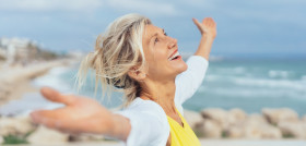 personas Mayores_Joyful woman enjoying the freedom of the beach