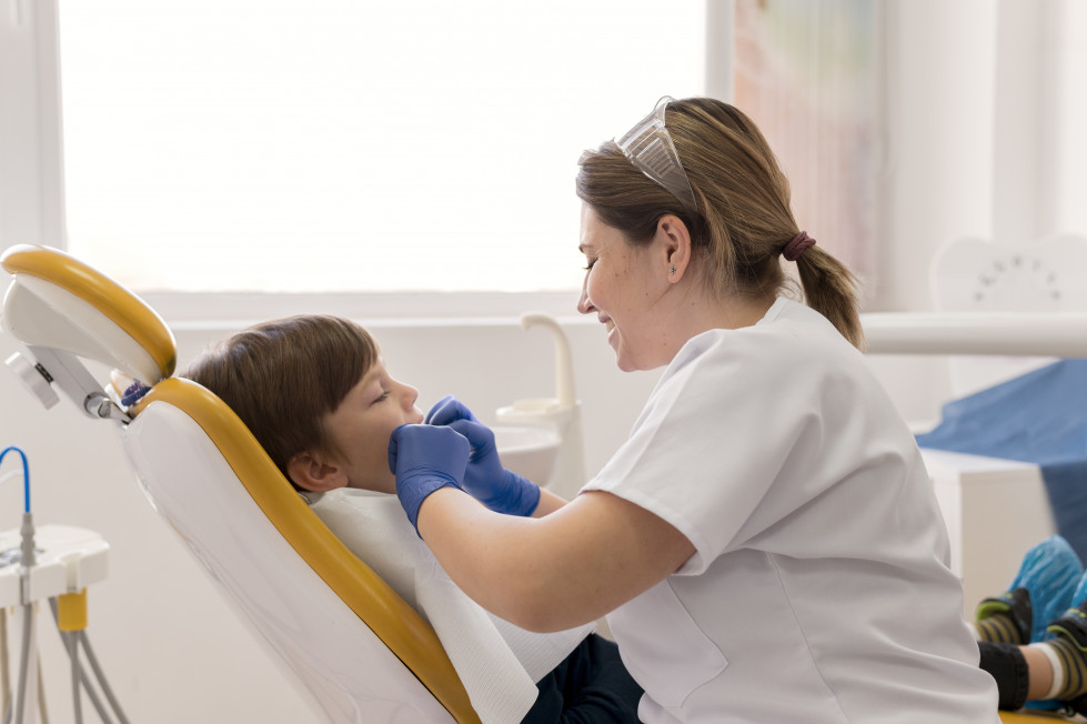 Dentista limpiando los dientes del nino