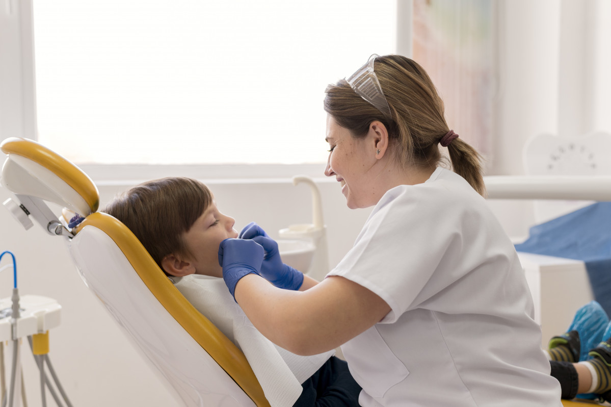 Dentista limpiando los dientes del nino